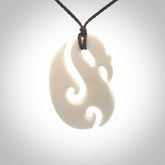 Hand carved bone manaia pendant with paua shell eye inlay. Hand made bone pendant.